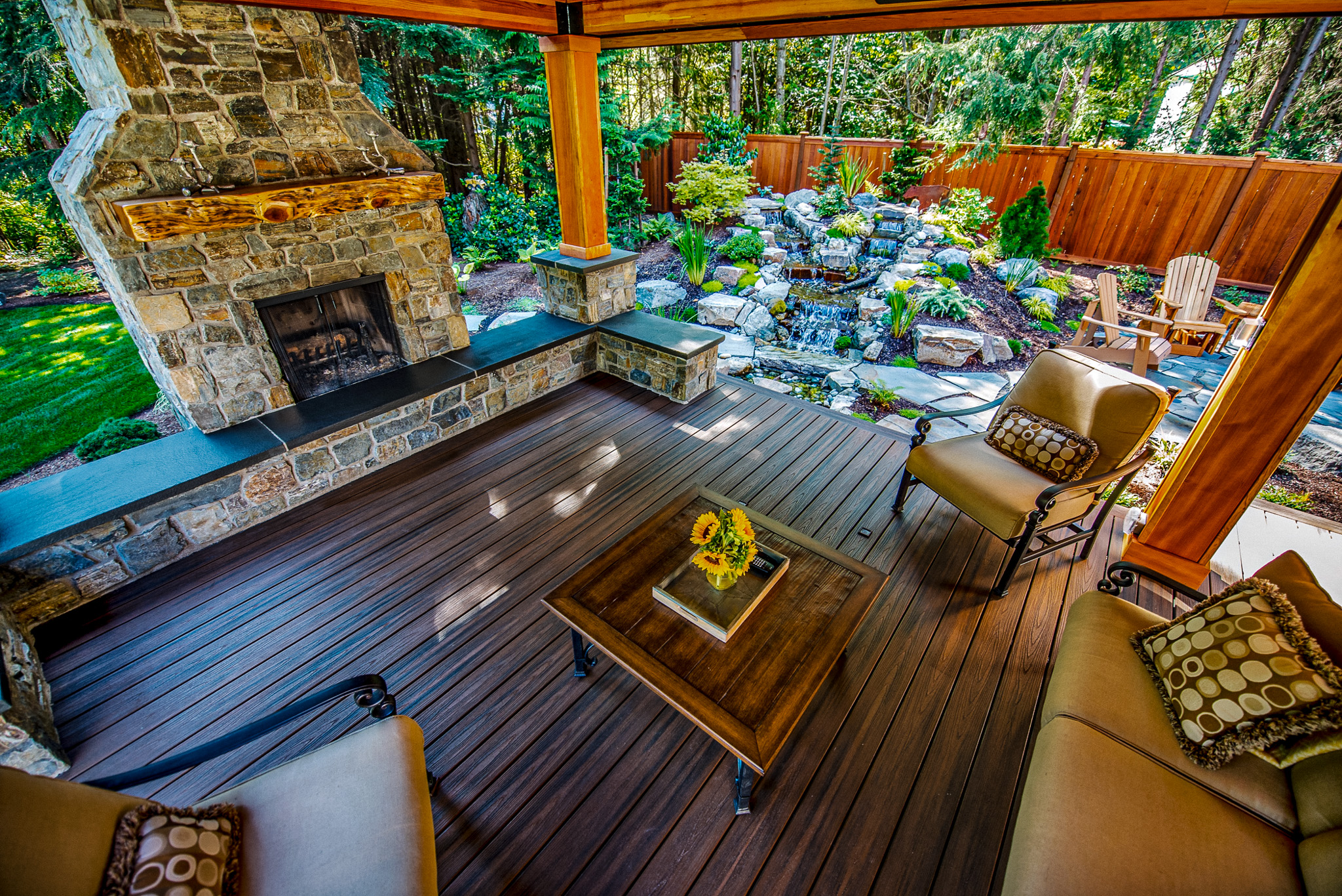 Outdoor living space bordered by a natural stone water feature