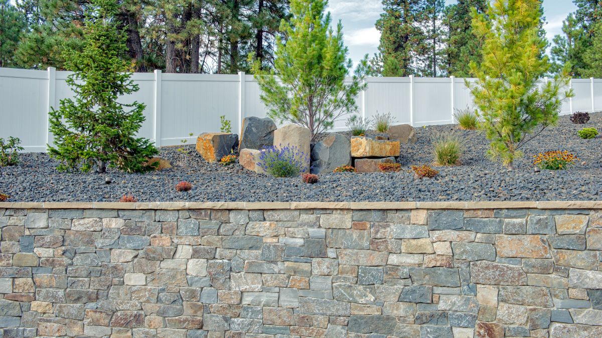 Retaining wall faced with natural stone veneer