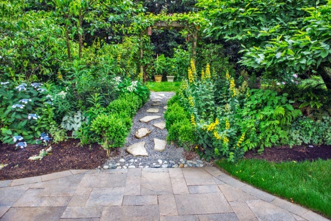 Flagstone stepping stones lead to large format paver patio