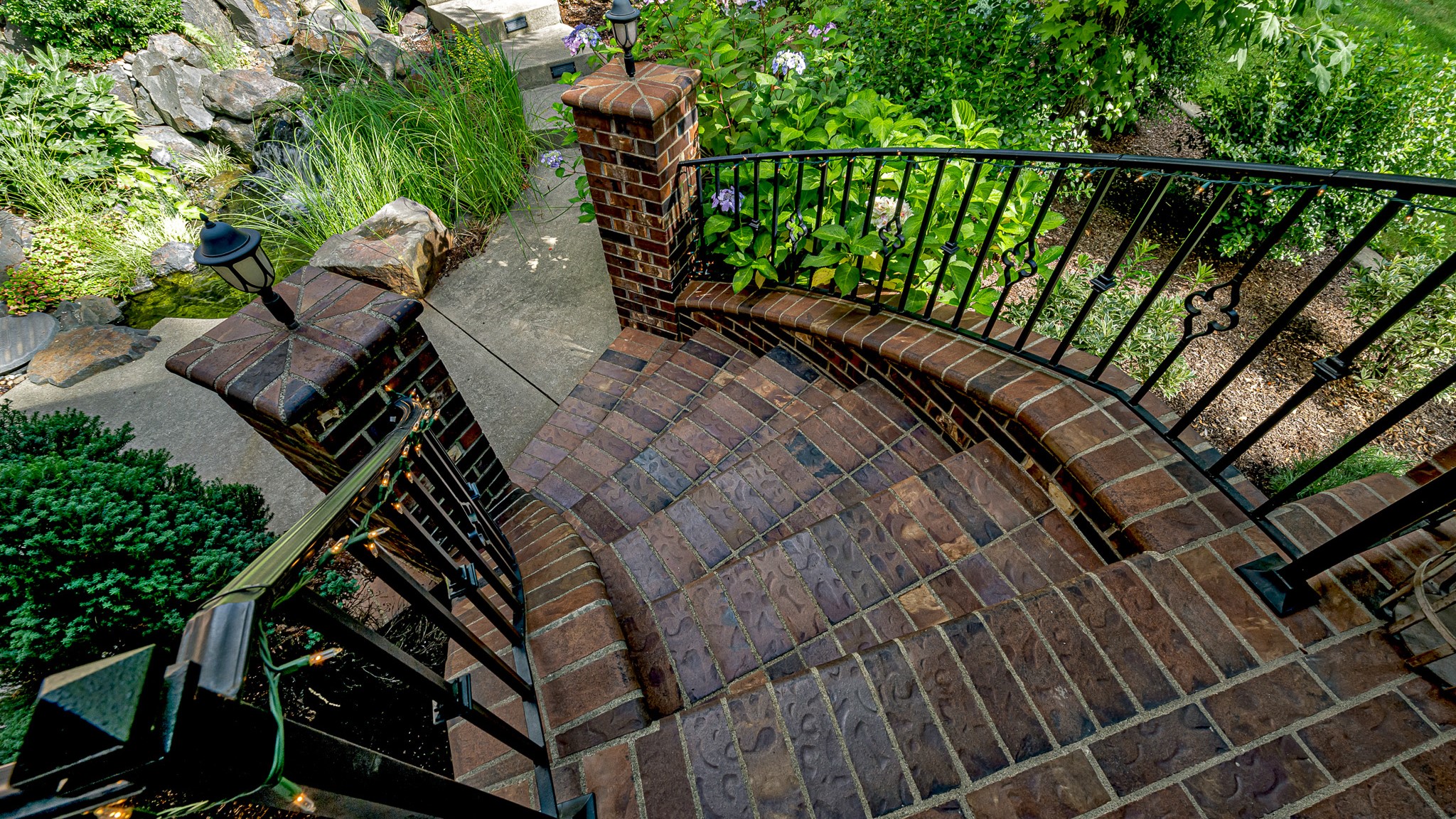 Outdoor staircase and columns created using brown dimpled brick